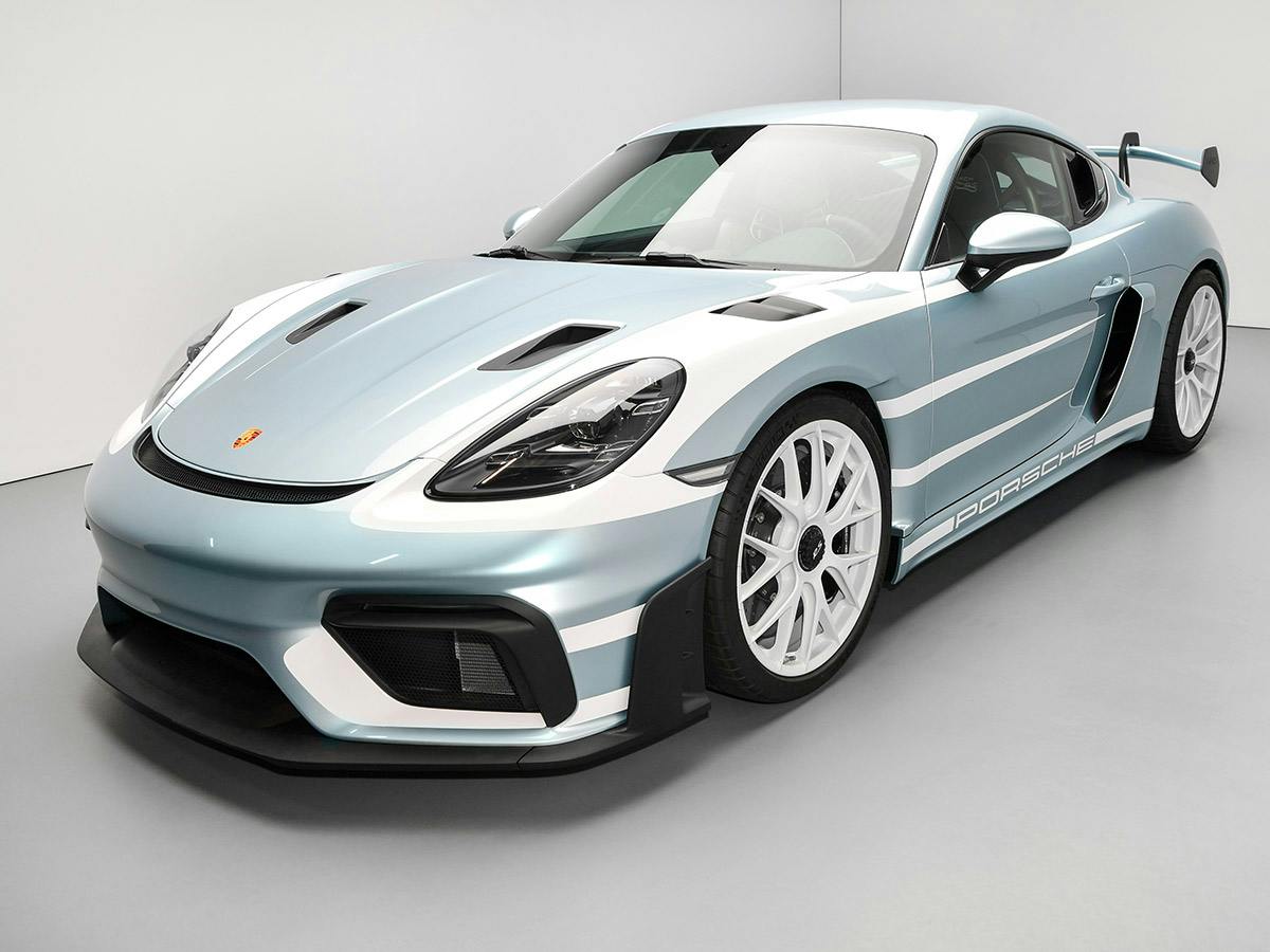 A Porsche 718 Cayman GT4 RS in Paint to Sample colour Azzurothetysmetallic, shown from a three-quarter front view in a white studio, featuring White design elements on the bonnet and side sills.