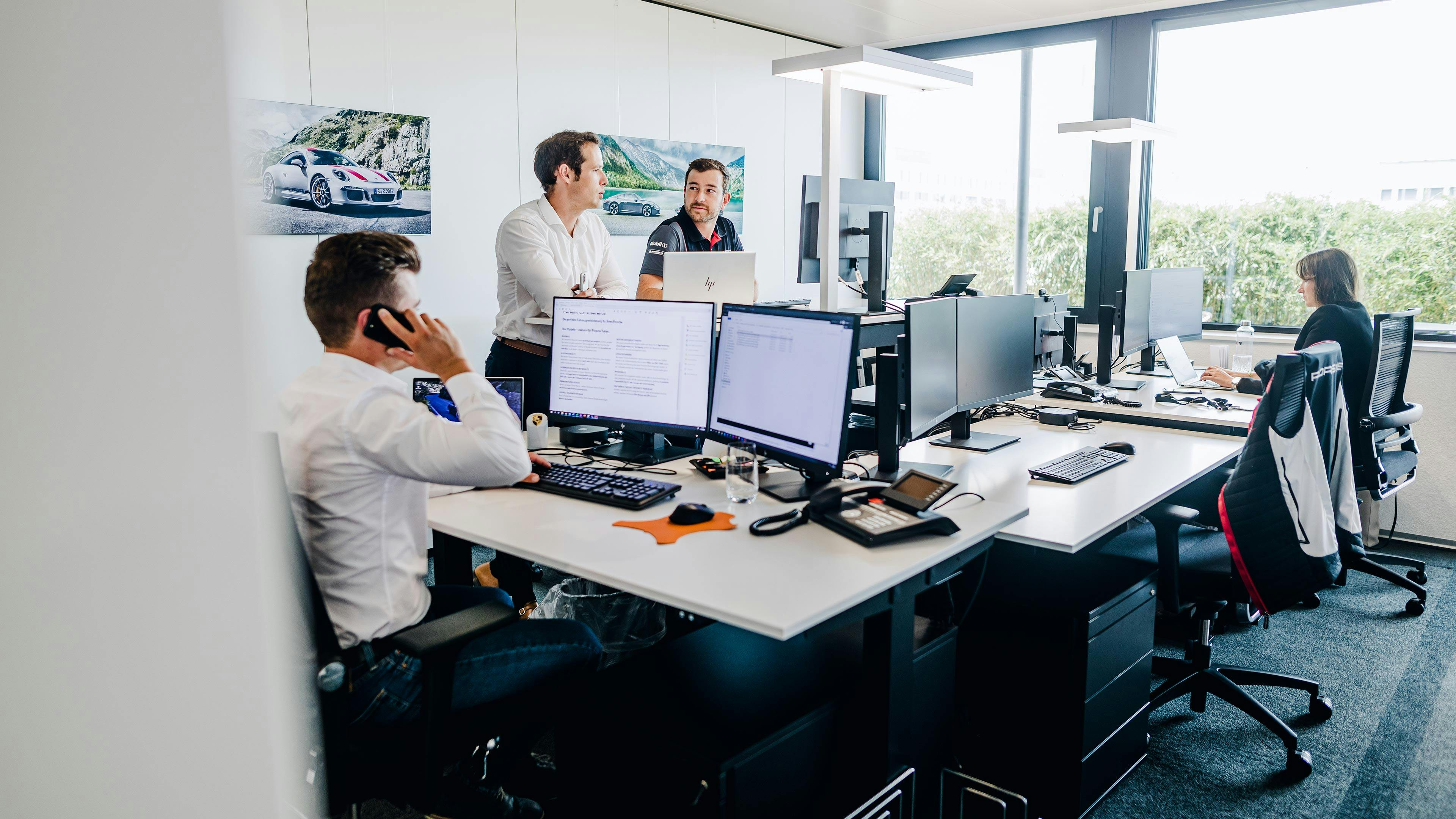 Arbeitende Menschen in einem Büro der Porsche Schweiz AG.