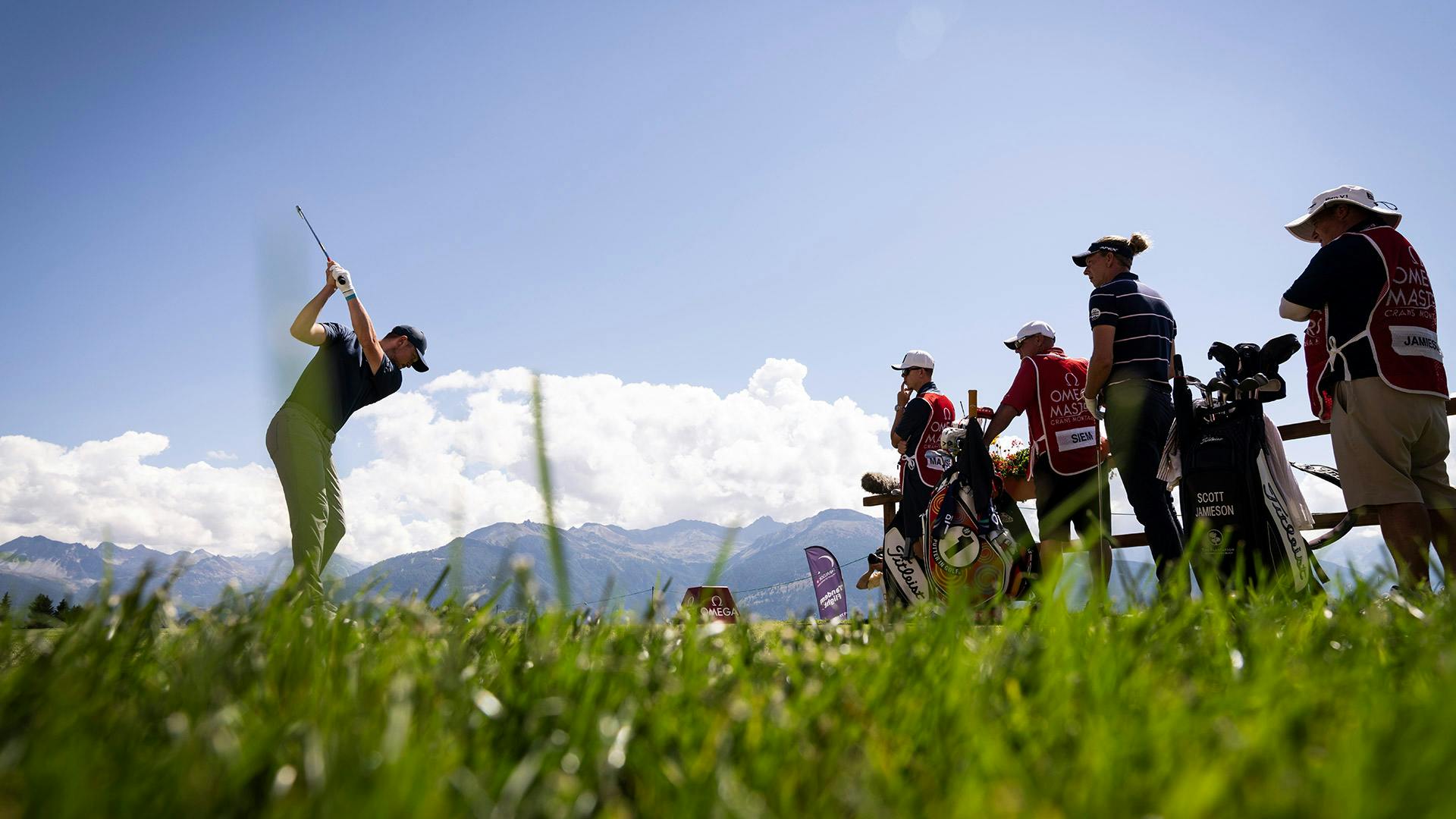 Ein Golfspieler beim Schlag vor Bergkulisse