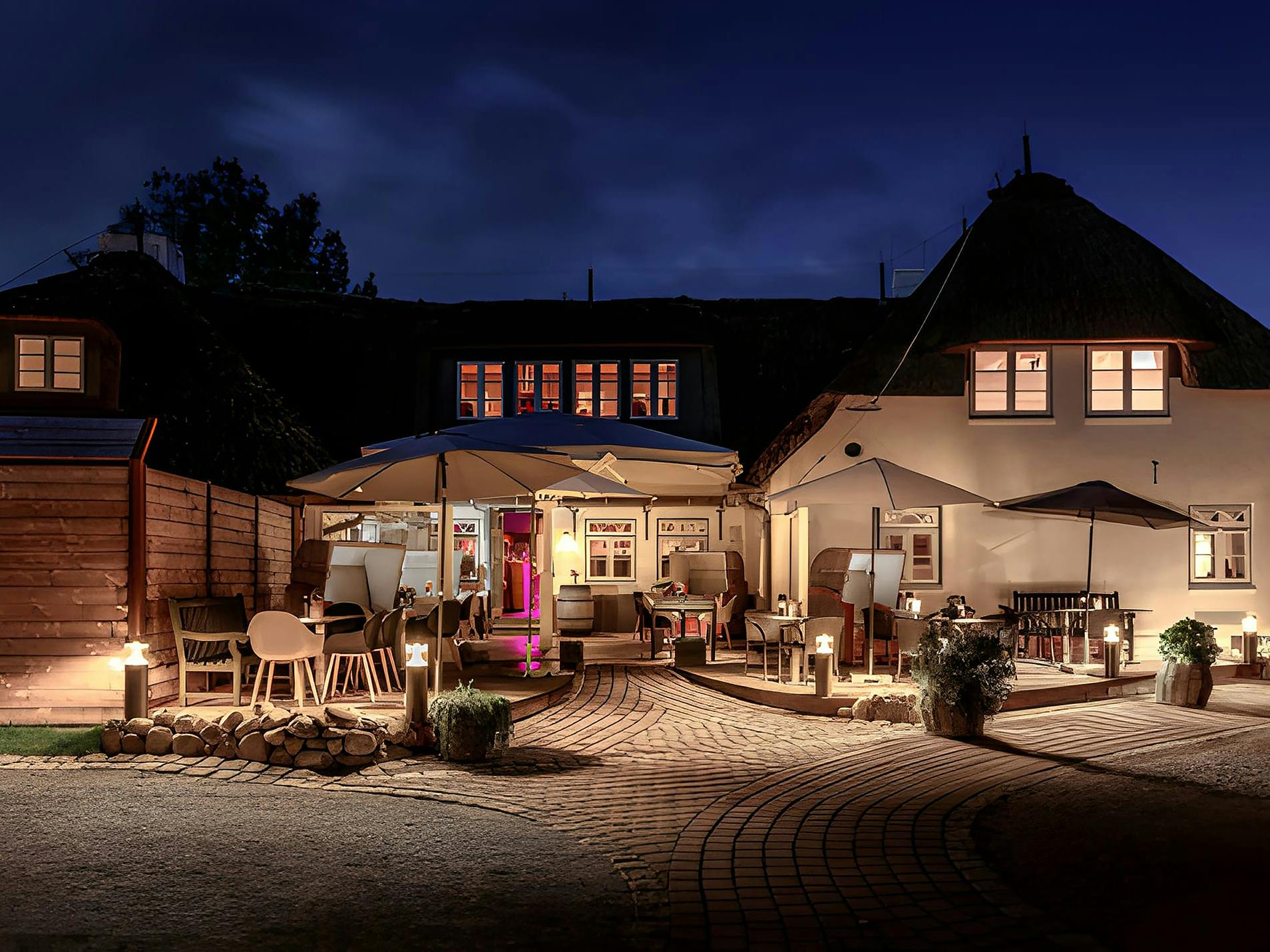 Landhaus Stricker al anochecer con iluminación festiva.