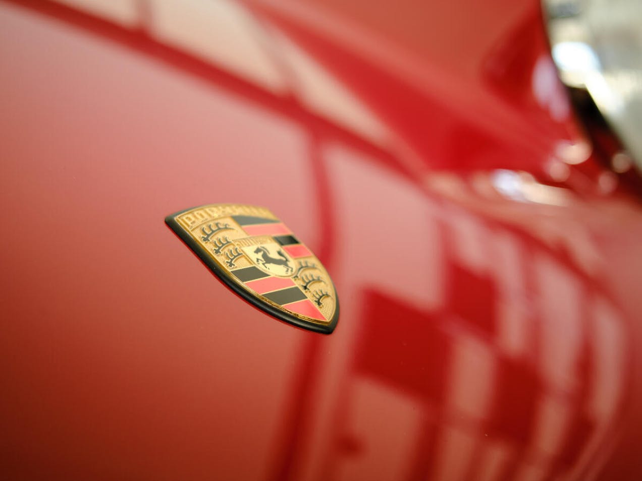 Detailed view of the Porsche crest on a classic Red Porsche.