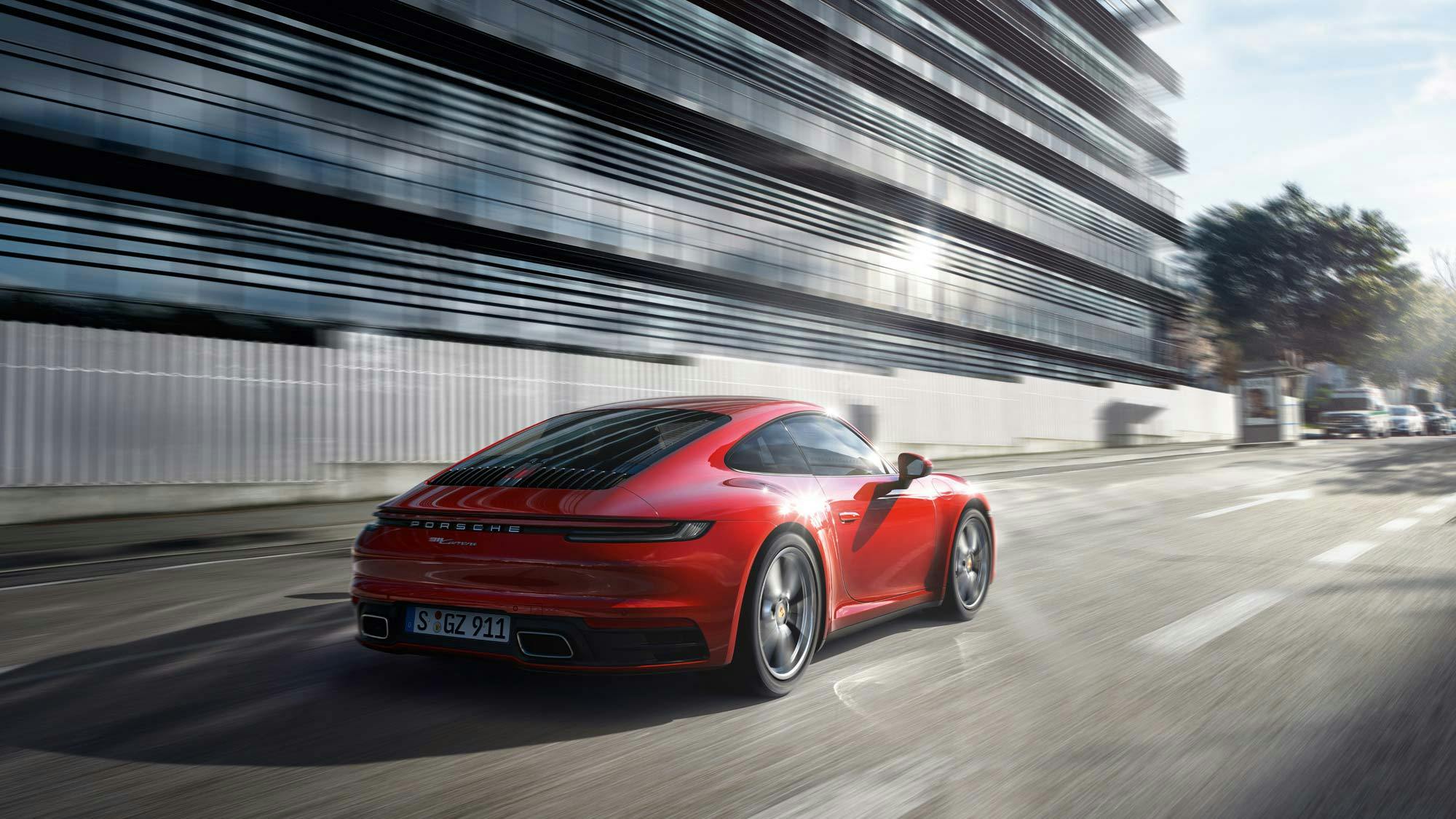 A red Porsche 911 driving in a fast lane.