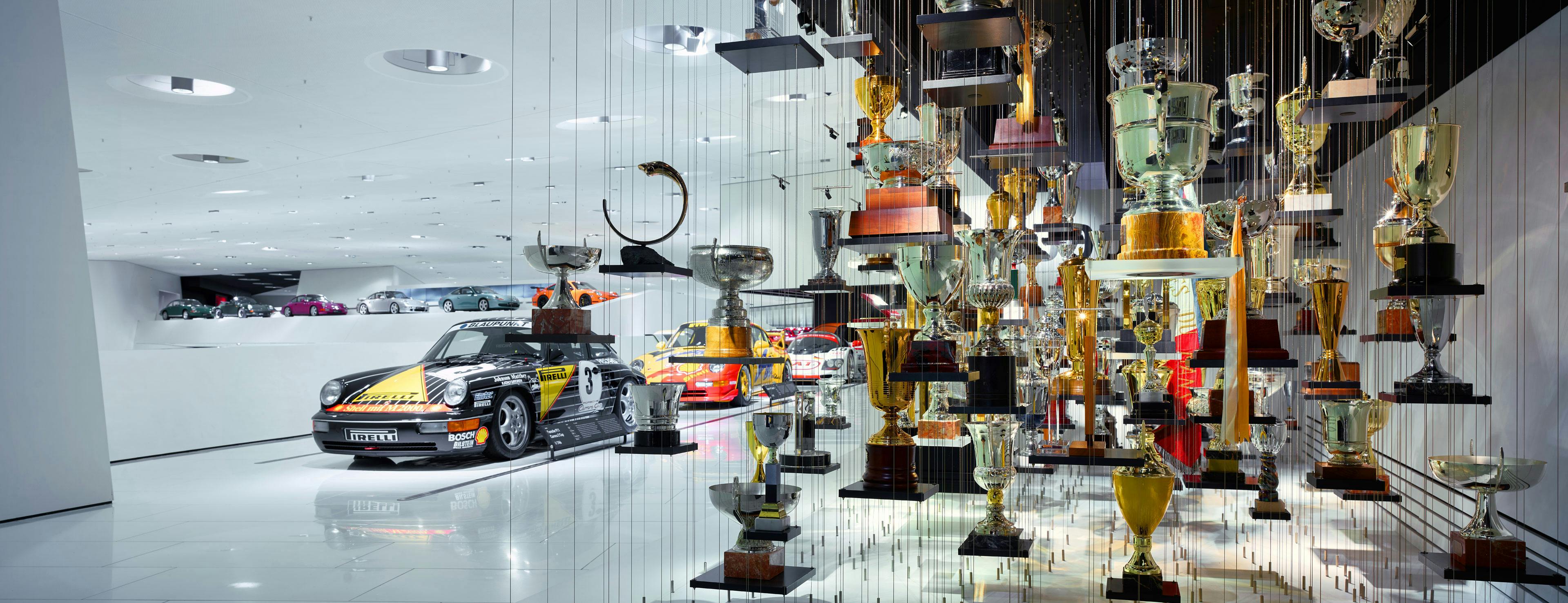 Eine Vitrine des Porsche Museums in dem viele Pokale ausgestellt sind
