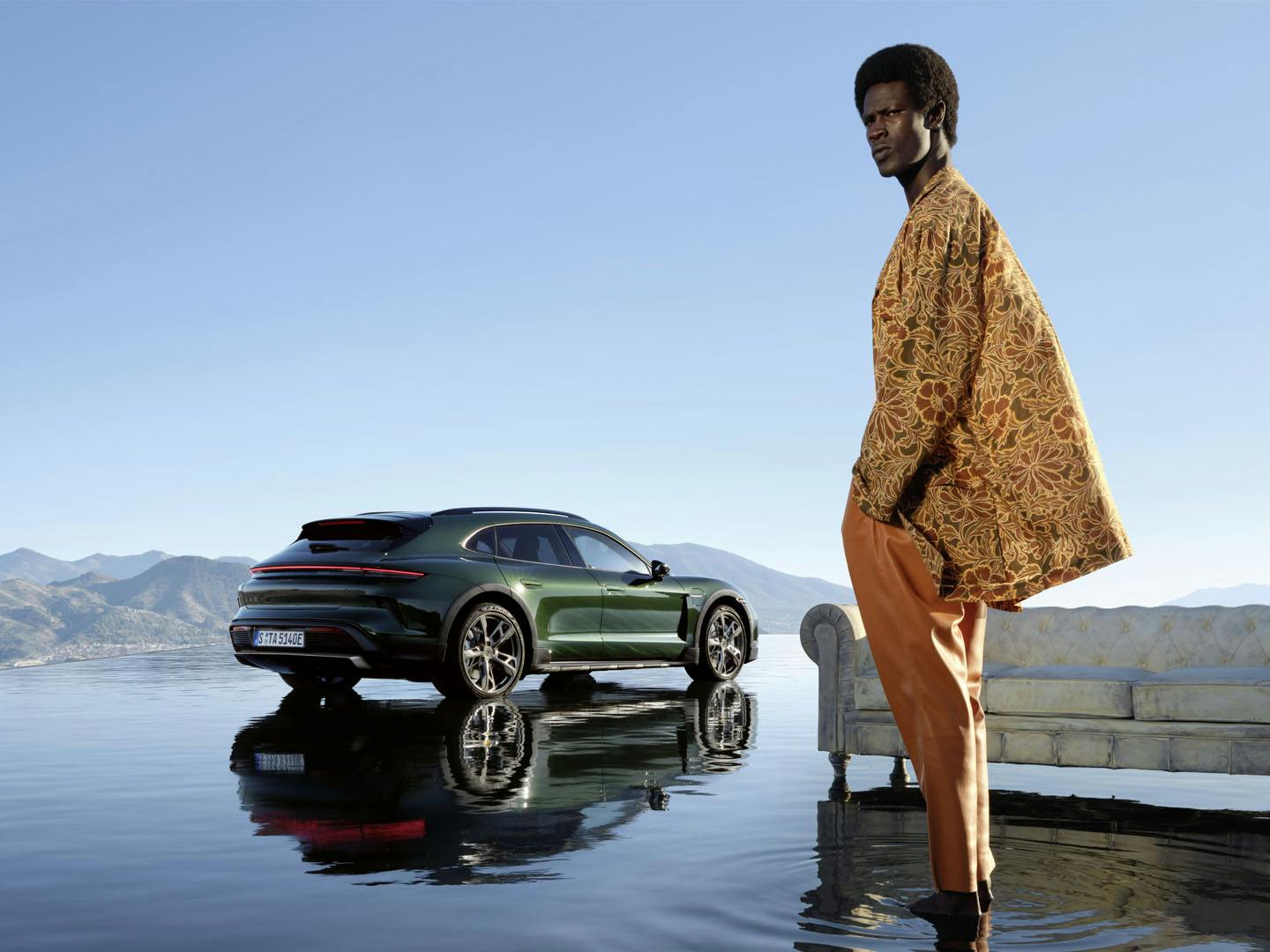 En man som står framför en grön Porsche Taycan