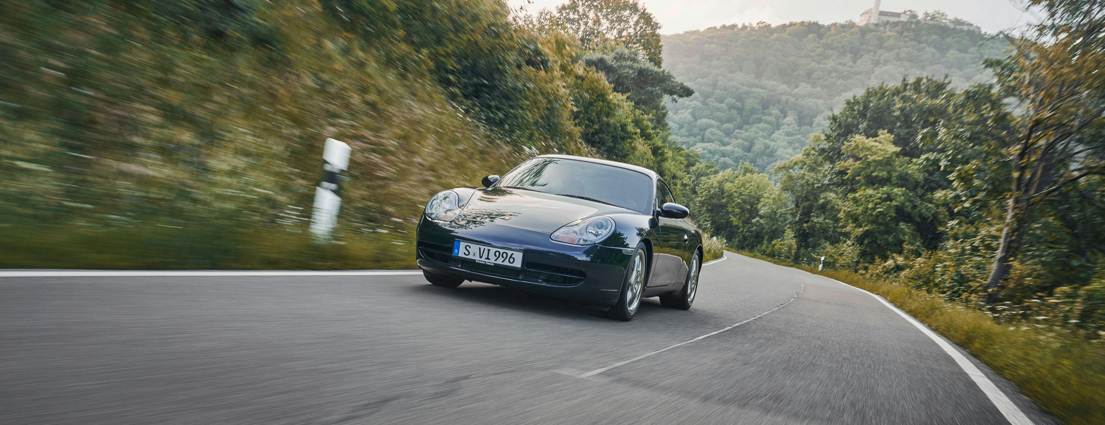 Porsche 911 (Type 996) driving along a country road.