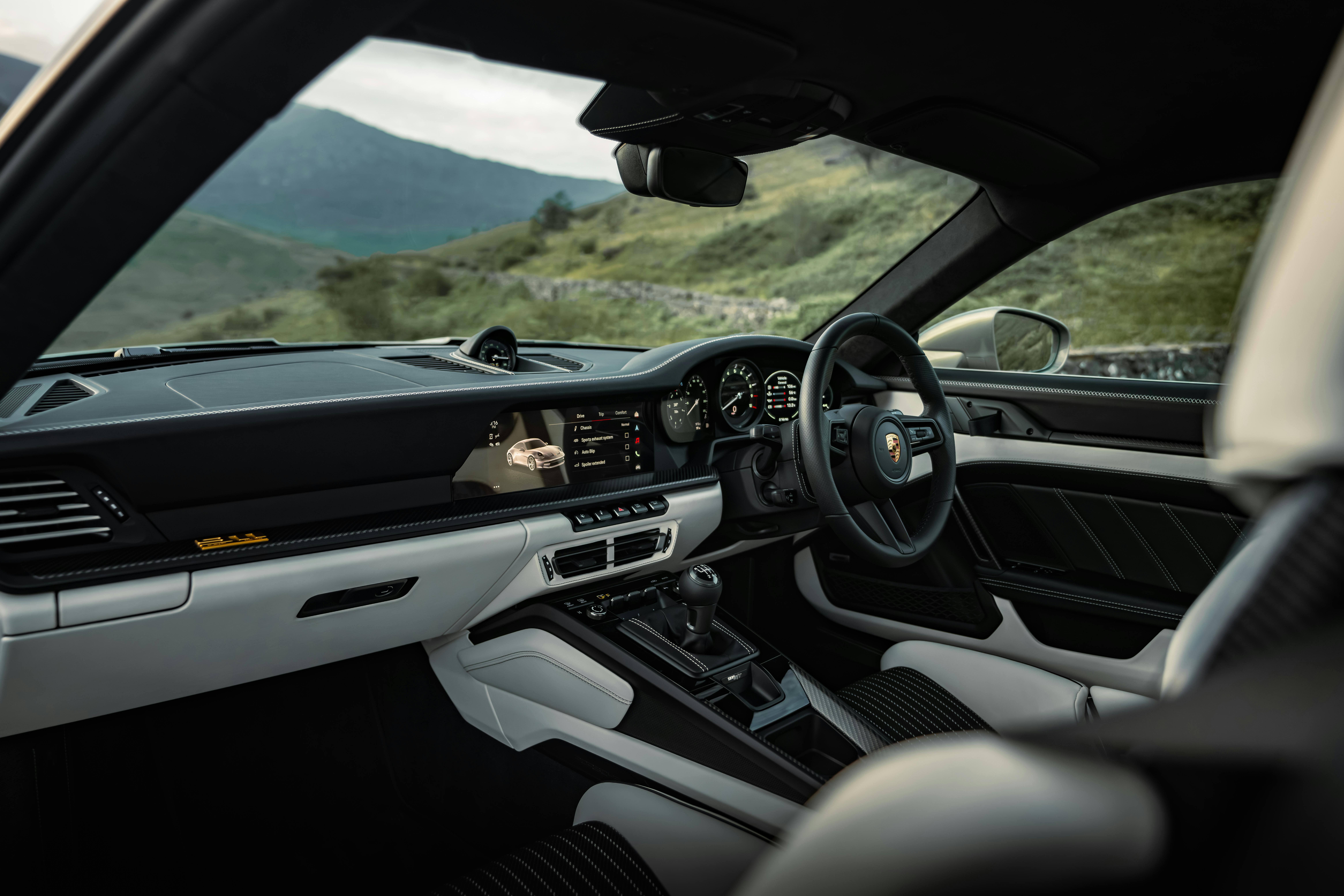 the interior of a  911 S/T in Chromaflair Urban Bamboo with countryside hills in the background.