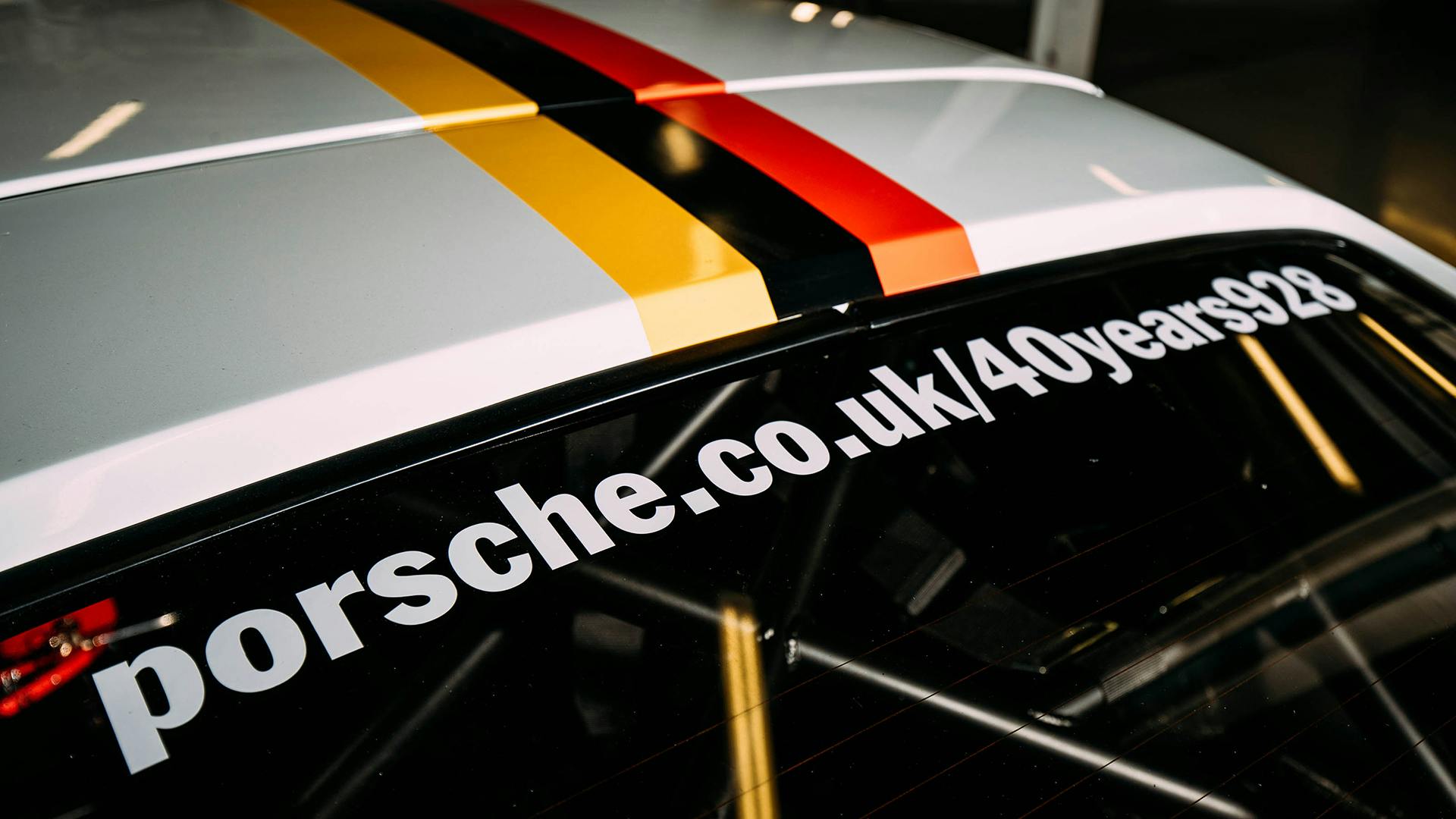 The stick-on lettering on the window of the Porsche 928 says: porsche.co.uk/40years928"