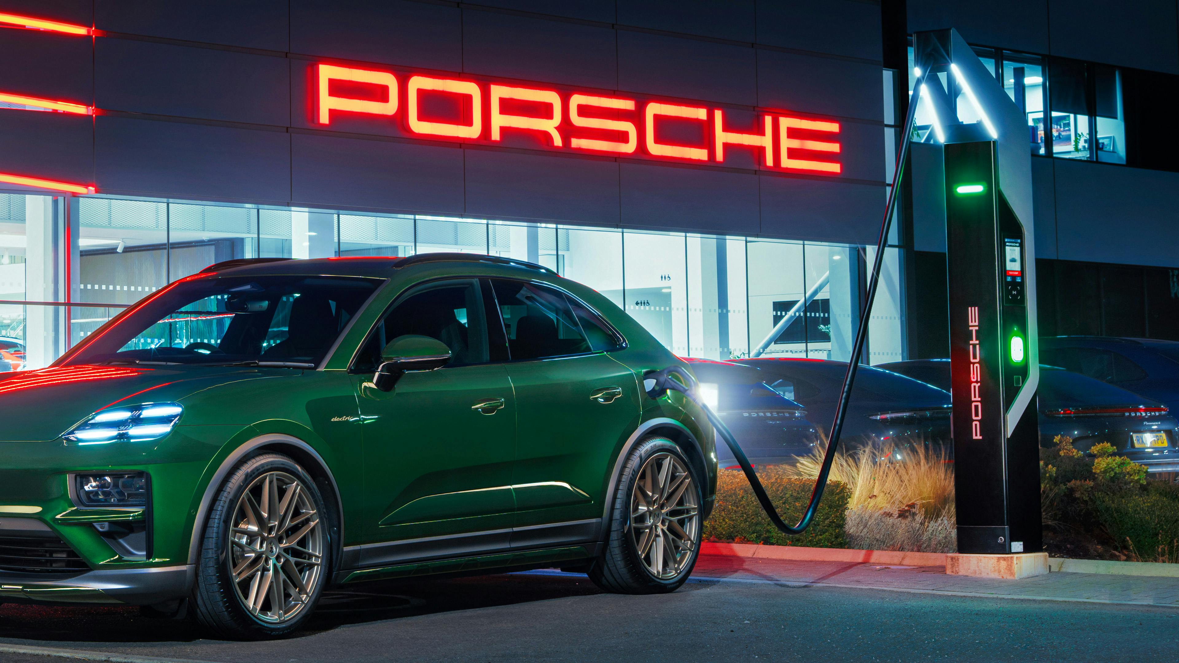 Porsche Macan Electric plugged in charging at Porsche Centre Reading during the night.