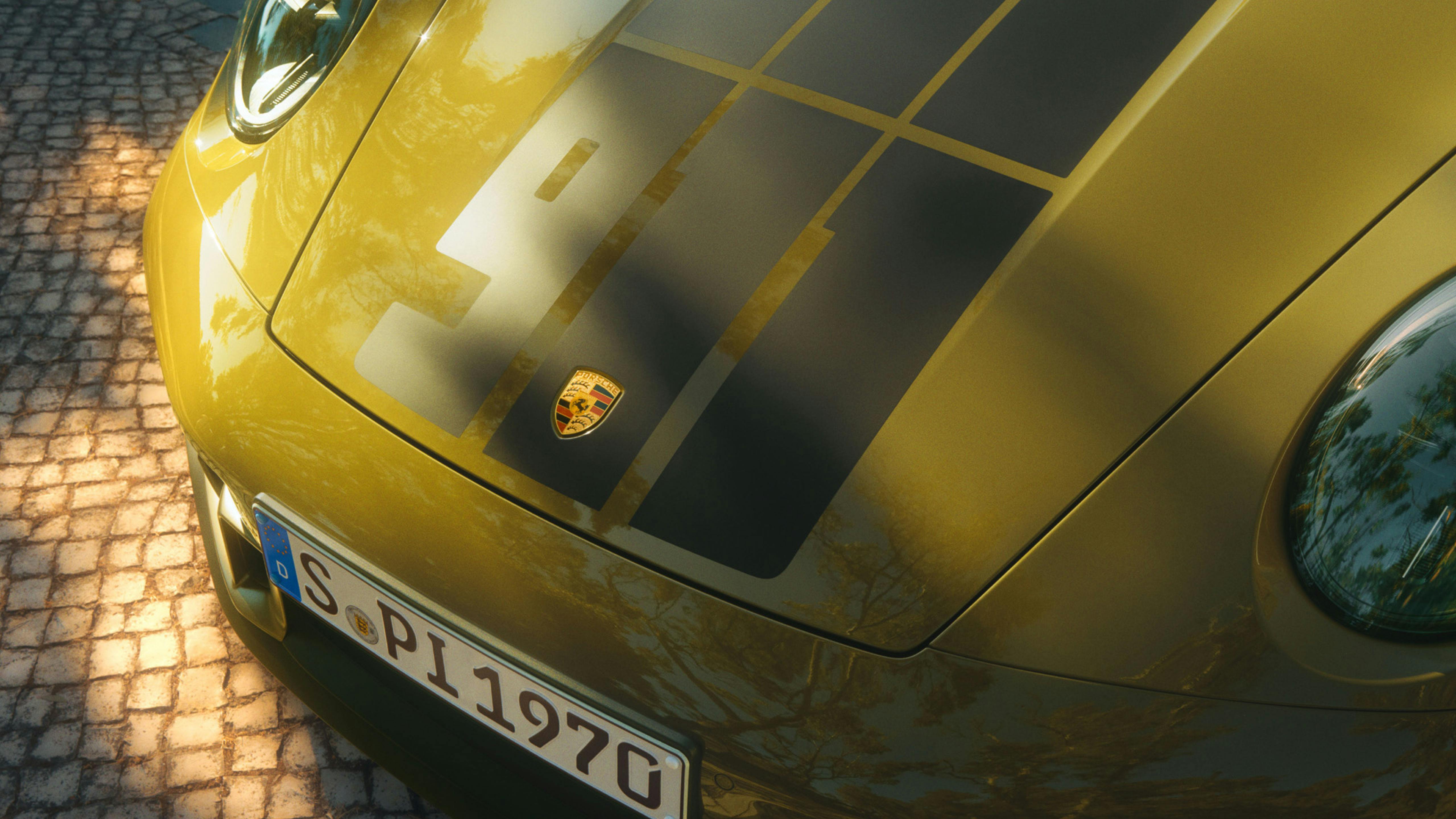 Vista de cerca del capó delantero de un Porsche 911 70 Spirit, mostrando el emblema de Porsche, el diseño gráfico "911" y la matrícula.