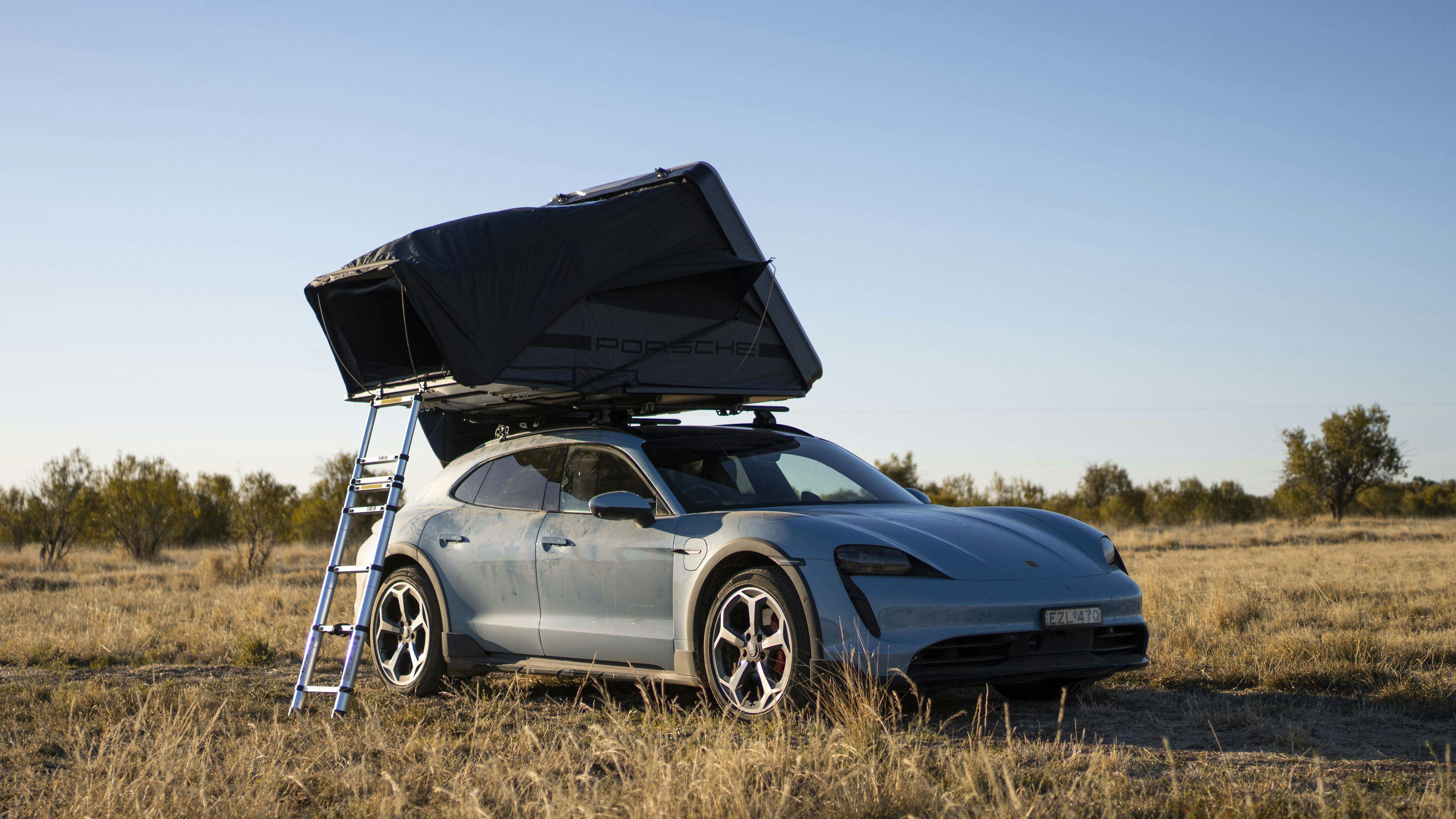 Porsche Taycan Cross Turismo camping in the bush with roof tent on top
