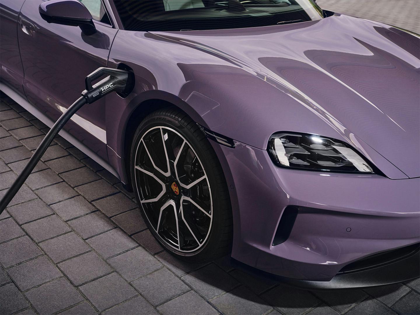 Une Porsche électrique violette en train de charger.