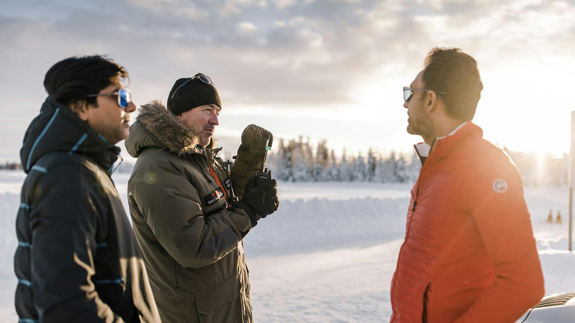 Participants of the Porsche Ice Experience in Finland talking to a Porsche instructor.
