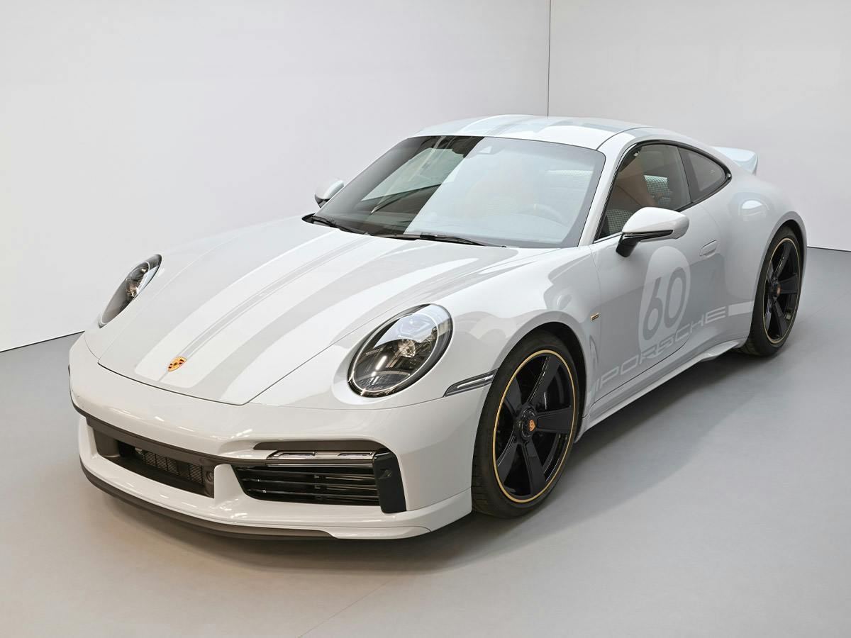 A Porsche 911 Sport Classic (992) in Sport Grey Metallic, shown from the left side view, featuring a white double stripe.