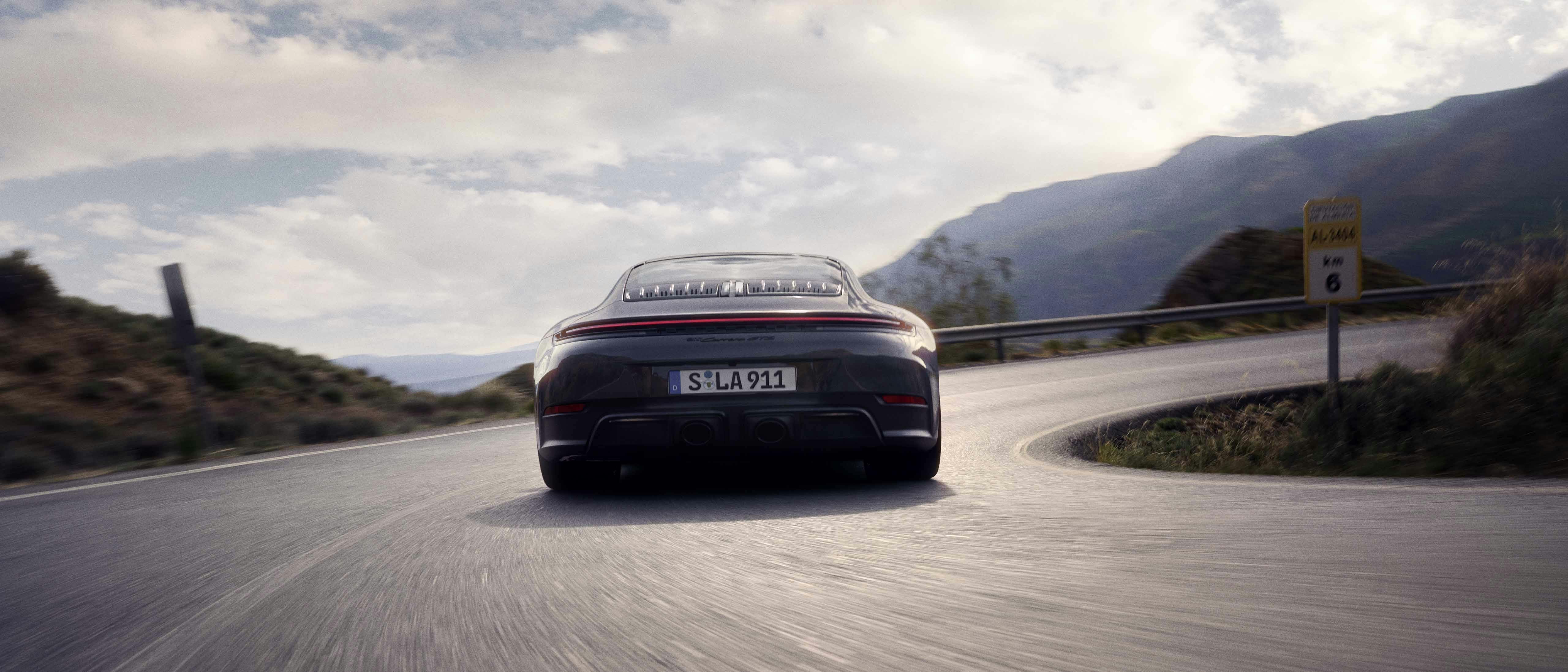 En Porsche 911 Carrera GTS kör på vägbanan i en skarp sväng.
