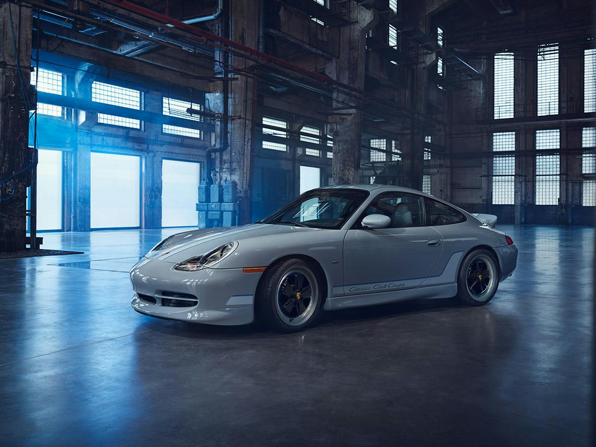 A 911 Classic Club Coupe coloured in Sport Grey Metallic standing in an old factory.