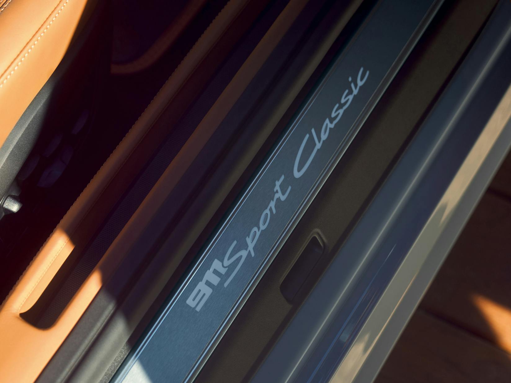 Detailed view of the door sill guard in Light Silver on the Porsche 911 Sport Classic.