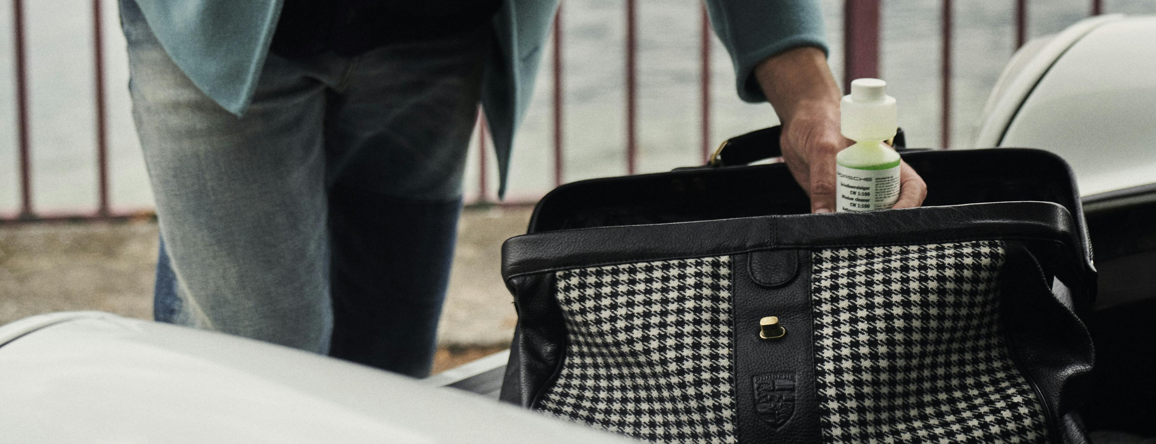 Man takes window cleaner out of the bag of the Car Care Set