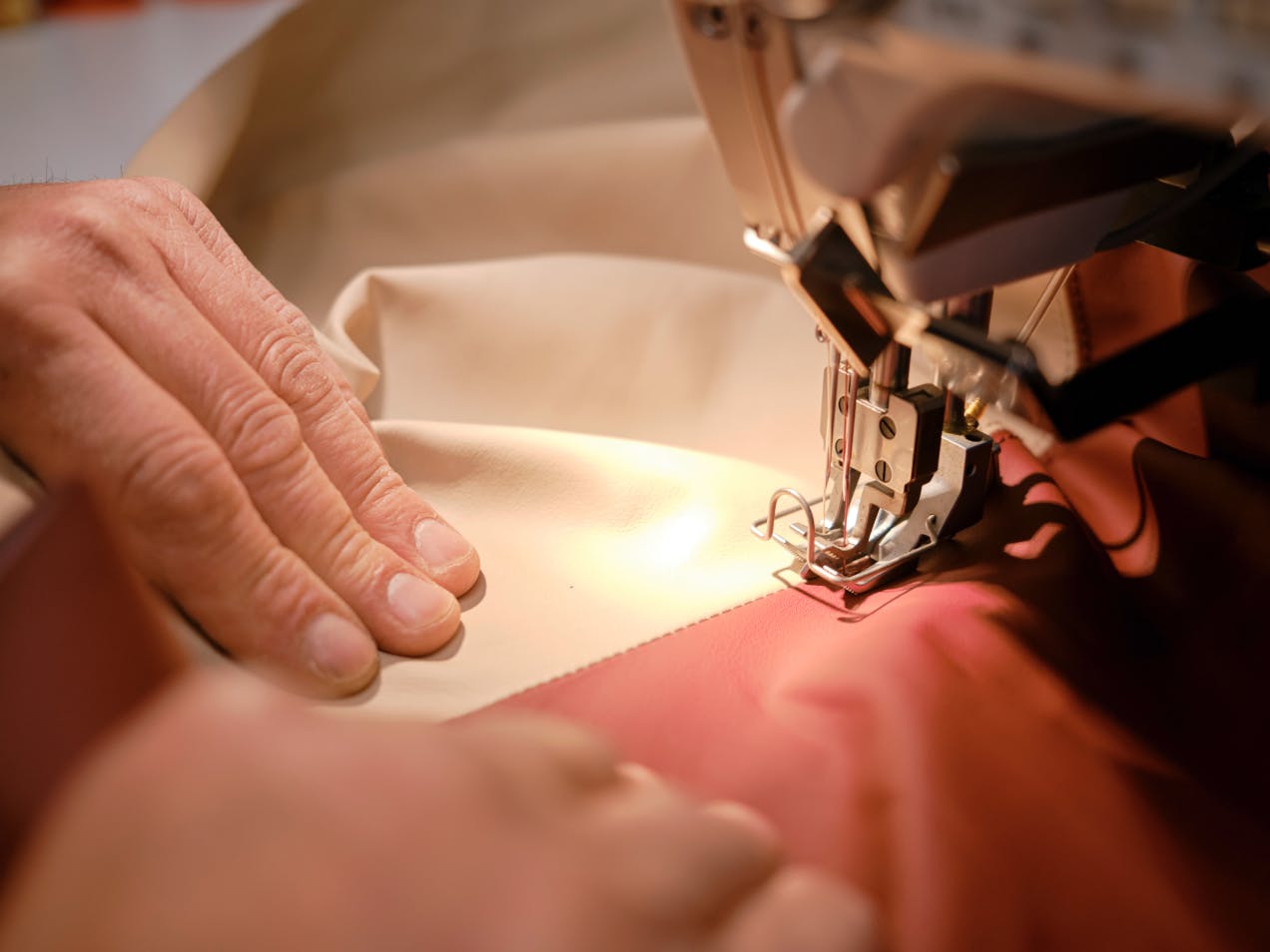 Two fabrics being sewn together with a sewing machine.