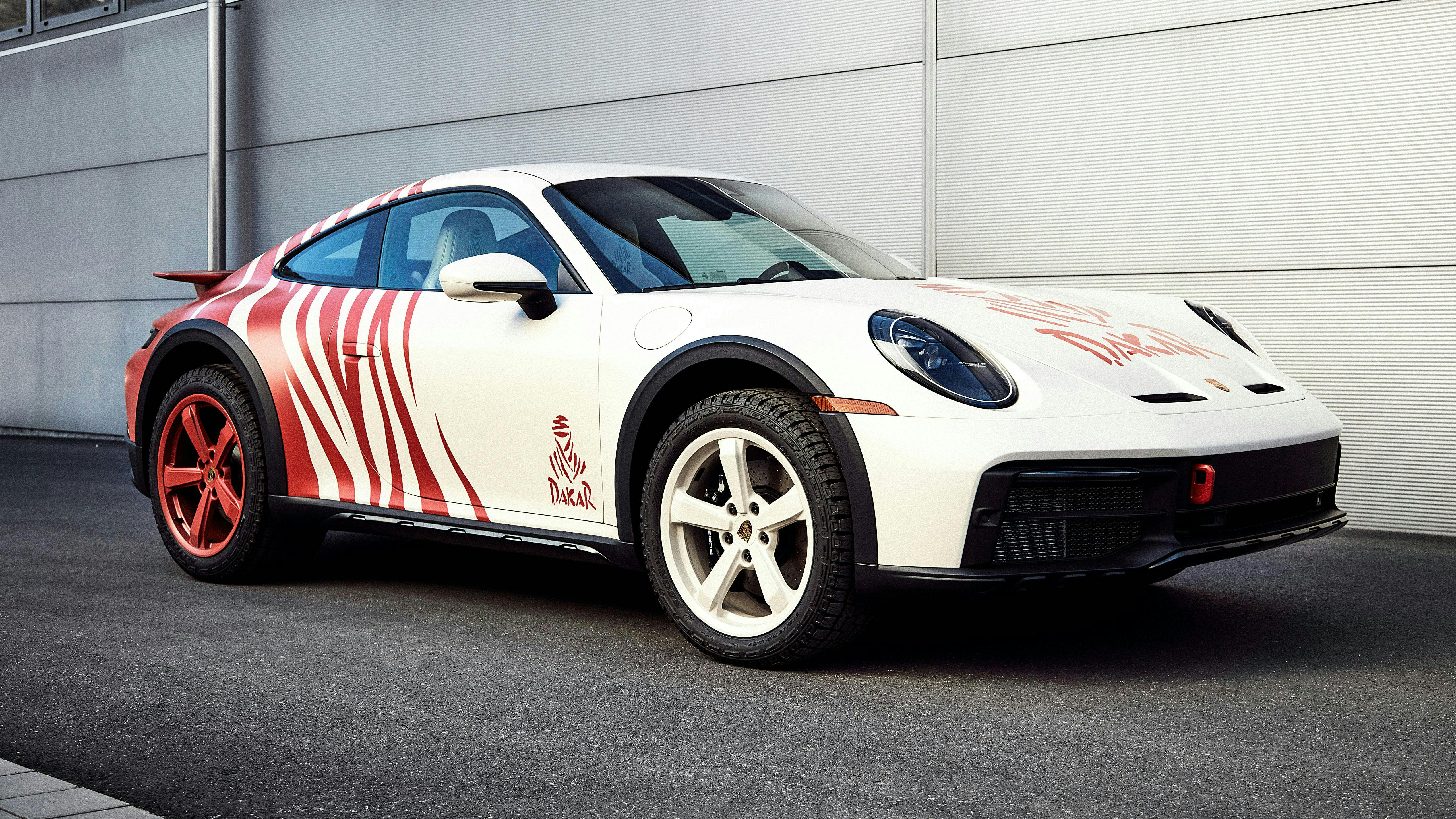 A 911 Dakar coloured in individual Design Painting in Tappan Red and white from the side with white front wheels and red back wheels.