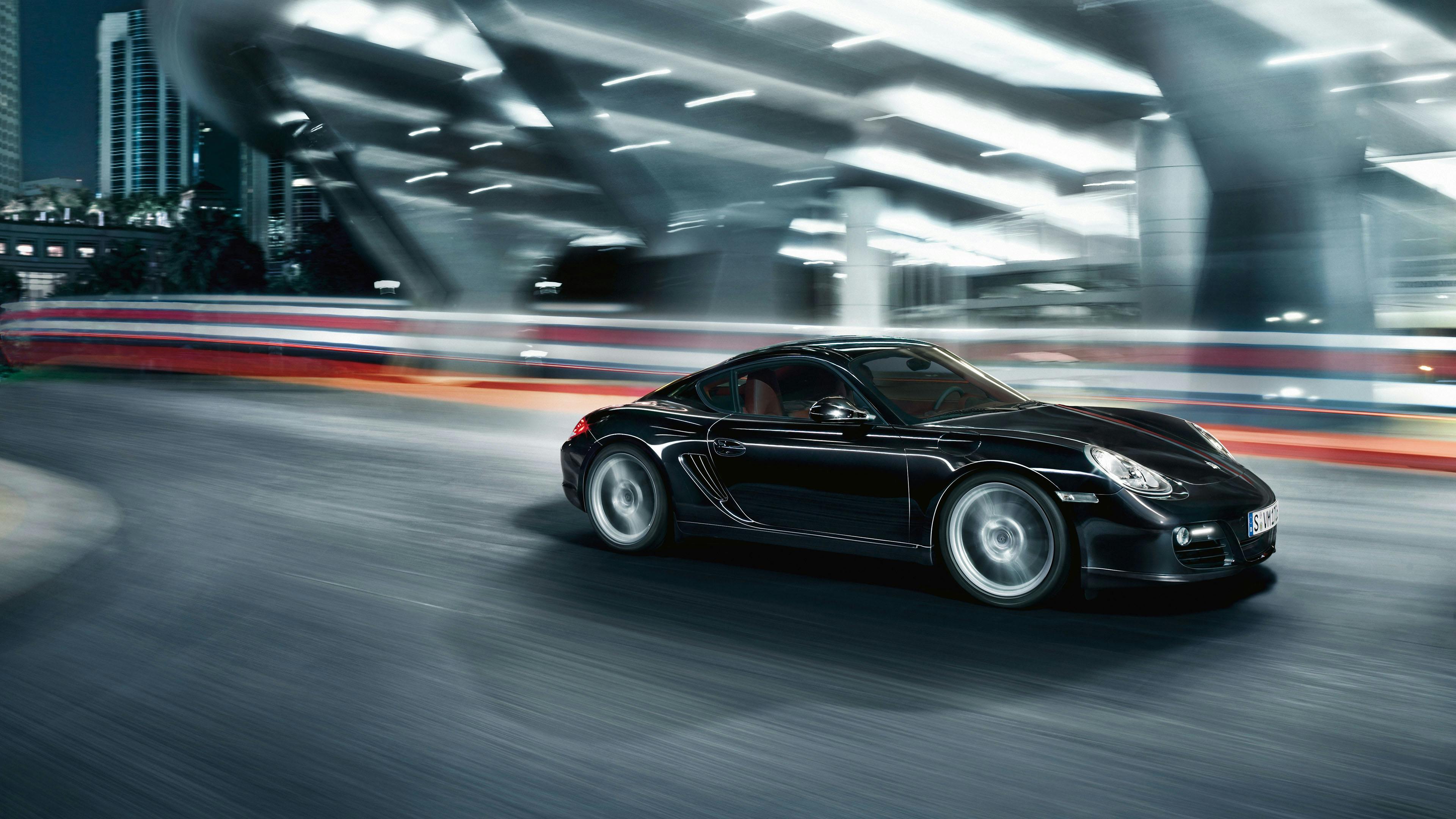 Cayman de color Negro con motor de 2.7 litros circulando por un entorno urbano.