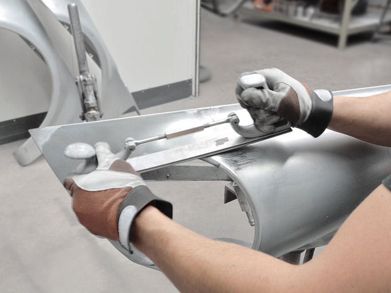 Workshop scene: finishing the weld, gloved hands