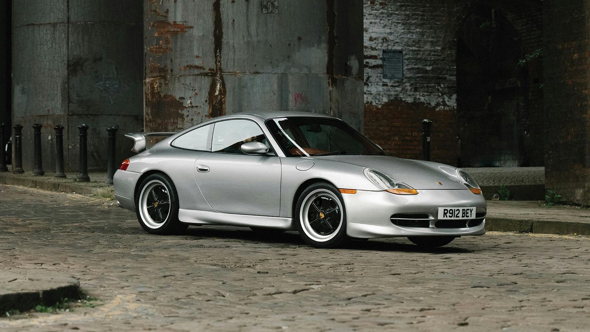 Auf Kopfsteinpflaster fahrender Porsche mit Fuchsfelgen.