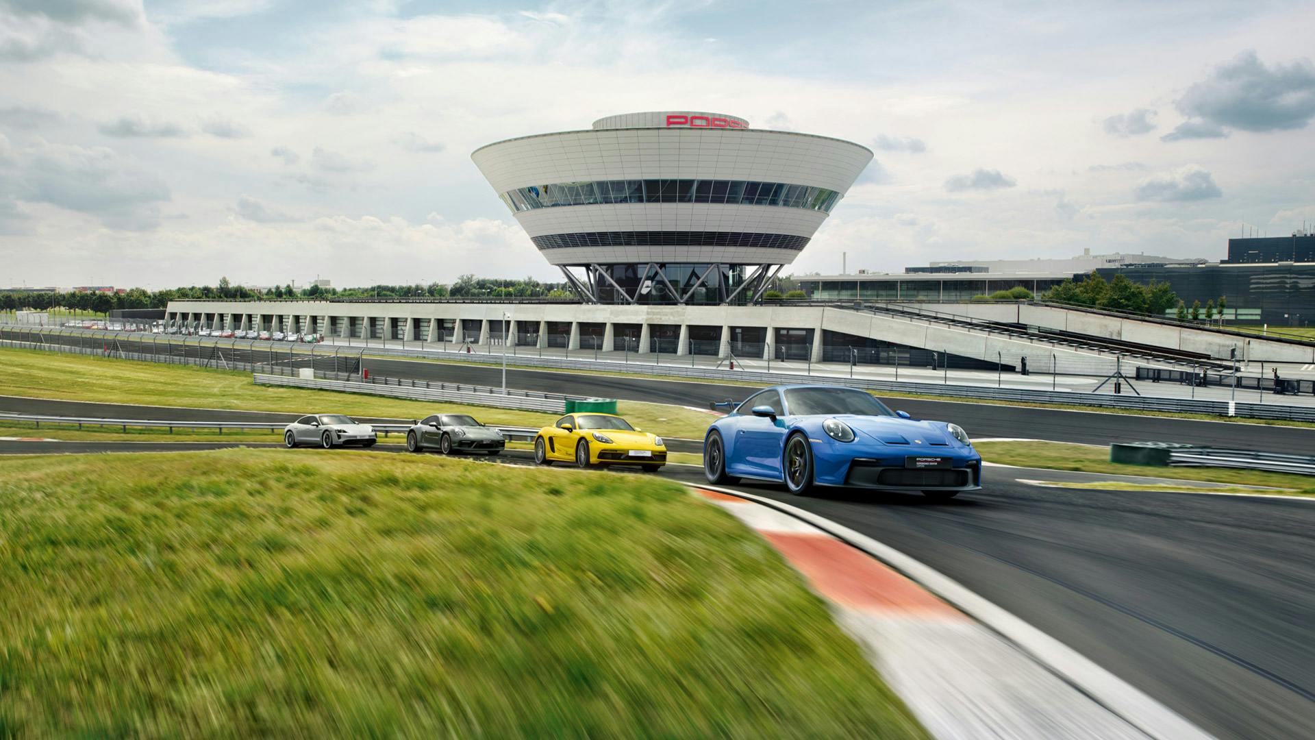 Vier Porsche fahrend auf dem Track des Porsche Experience Center Leipzig.
