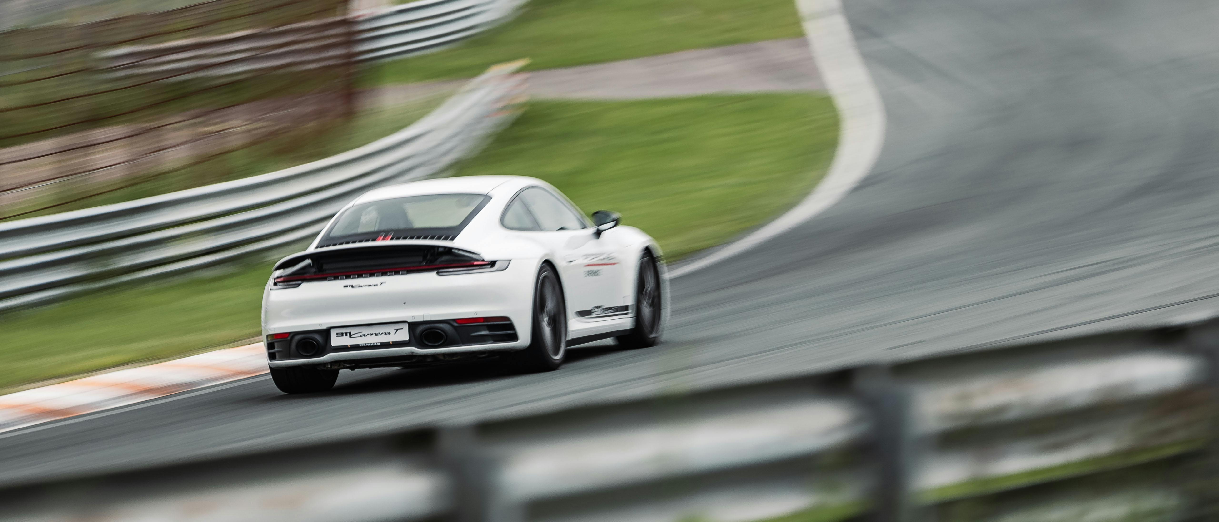 Twee Porsche auto's rijden op het circuit tijdens de Young Driver Experience