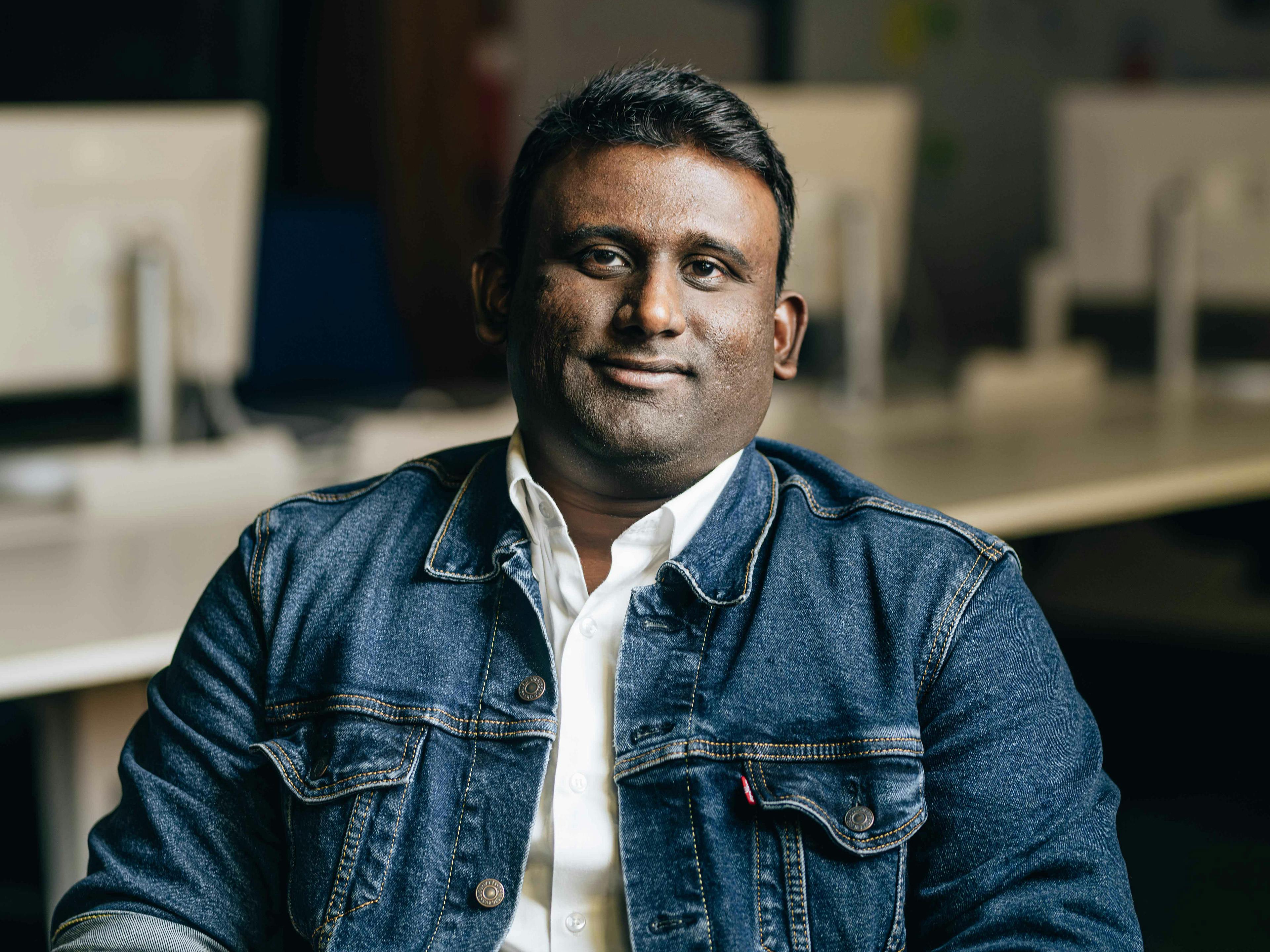 Der Porsche Mitarbeiter Sridhar lächelt in die Kamera.