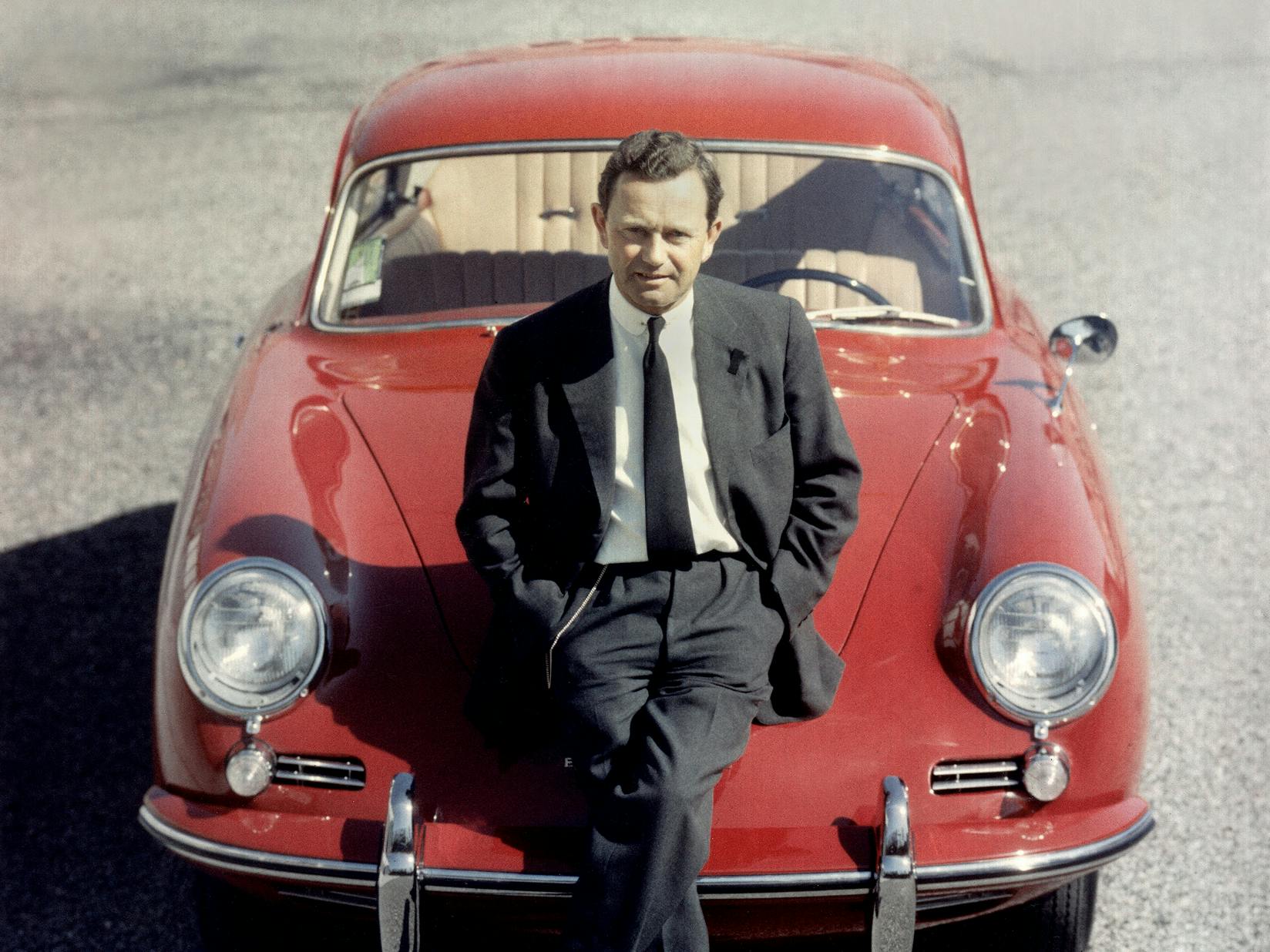 Ferry Porsche leaning against a classic Porsche model.