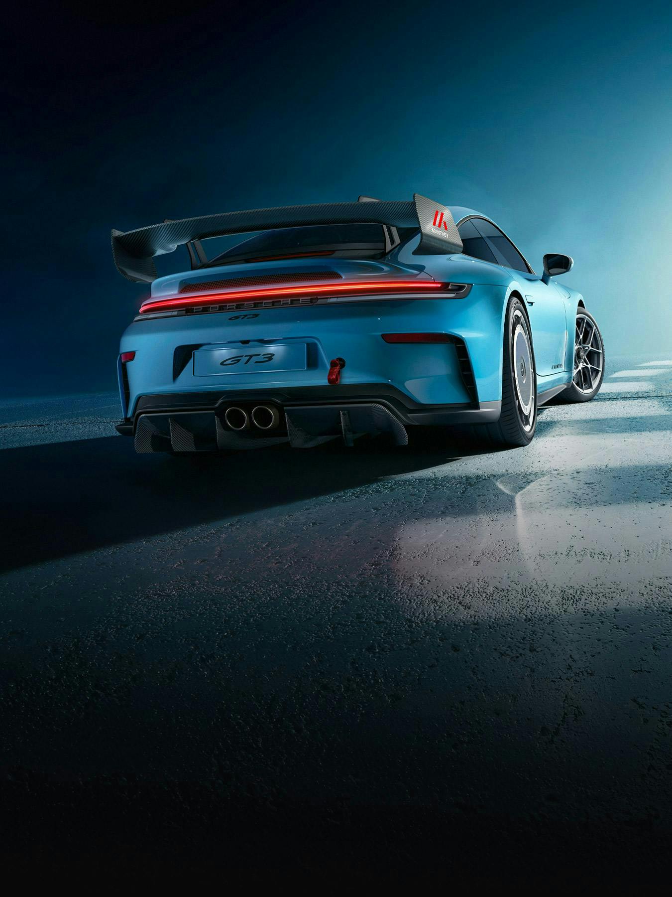 Vista trasera de un Porsche 911 GT3 (992) azul con kit de rendimiento Manthey.