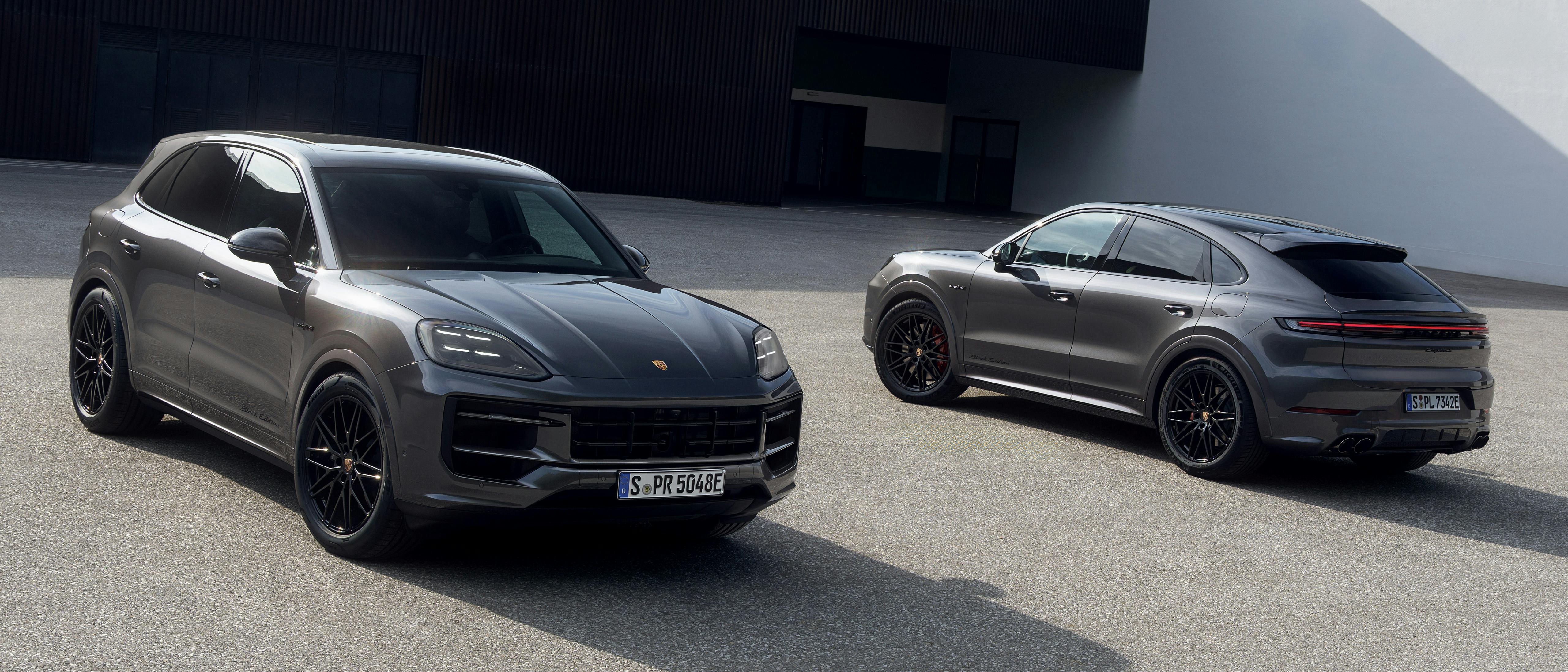 The Cayenne S E-Hybrid Coupé Black Edition and Cayenne E-Hybrid Black Edition parked close to one another in an open area, with a building in the background.