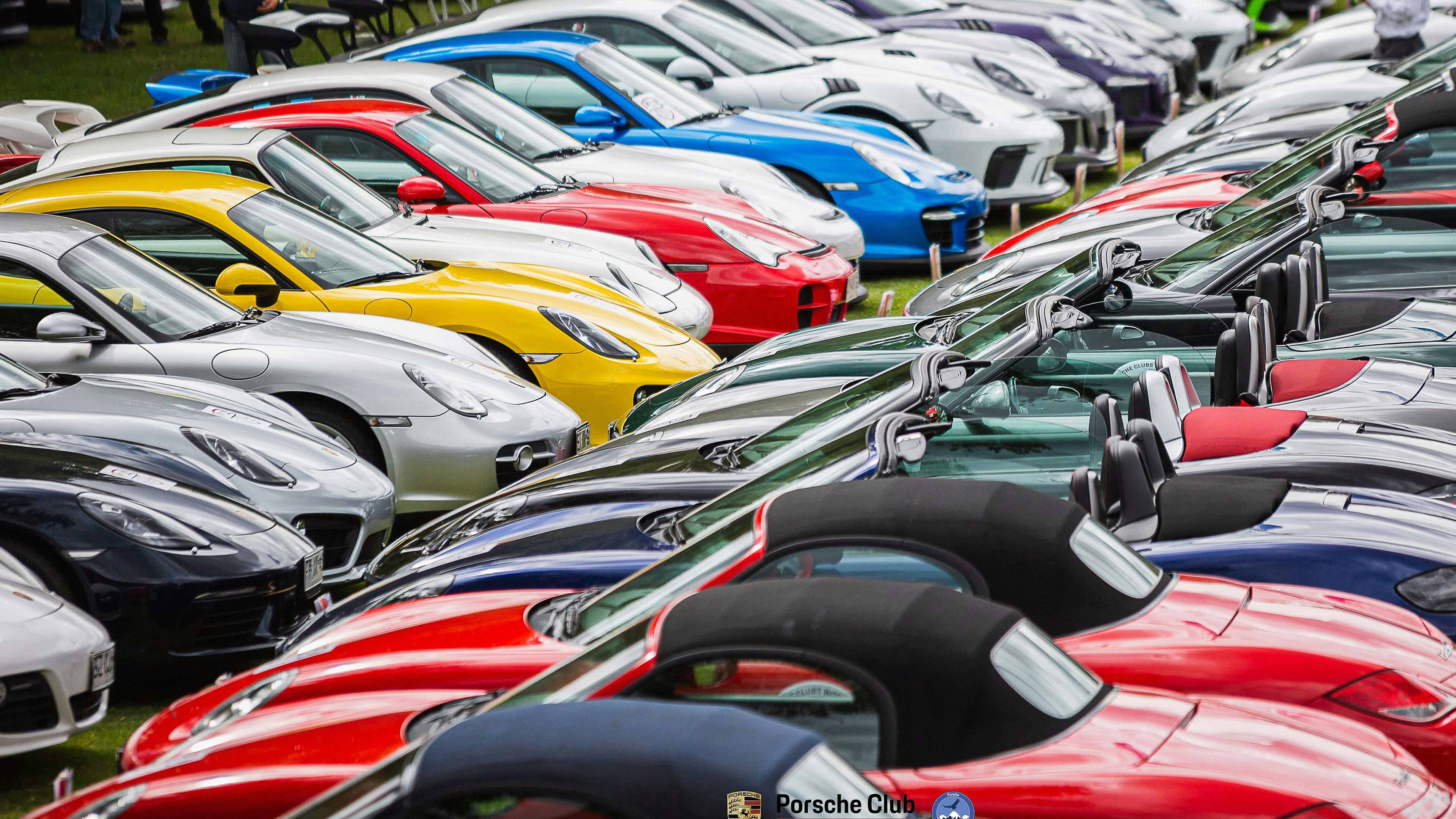 Porsche modellen naast elkaar geparkeerd.
